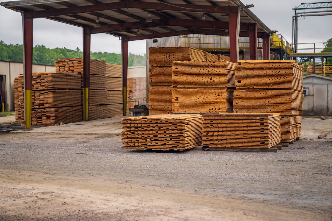 Stacks of timber planks at an outdoor lumber yard, showcasing construction supplies.
